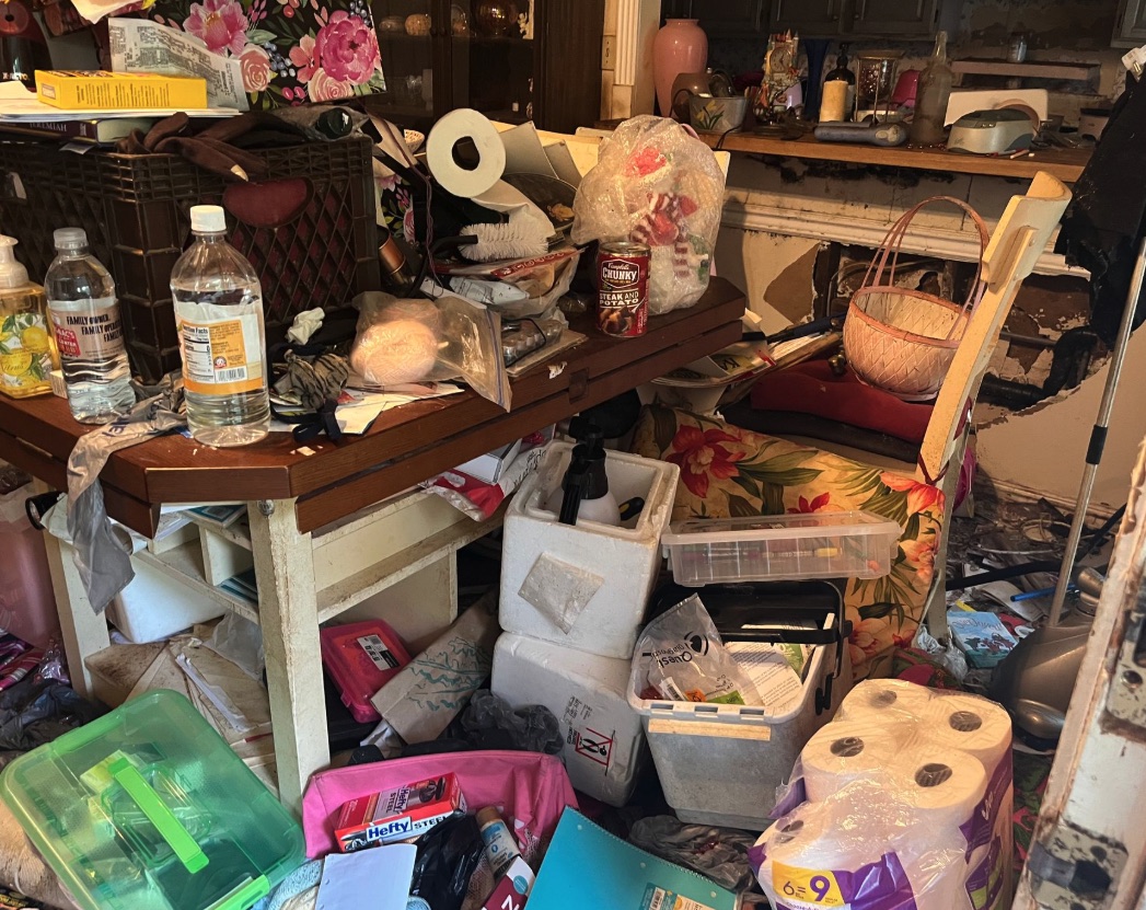 Packed kitchen table and household supplies before a Farmington hoarding cleanup